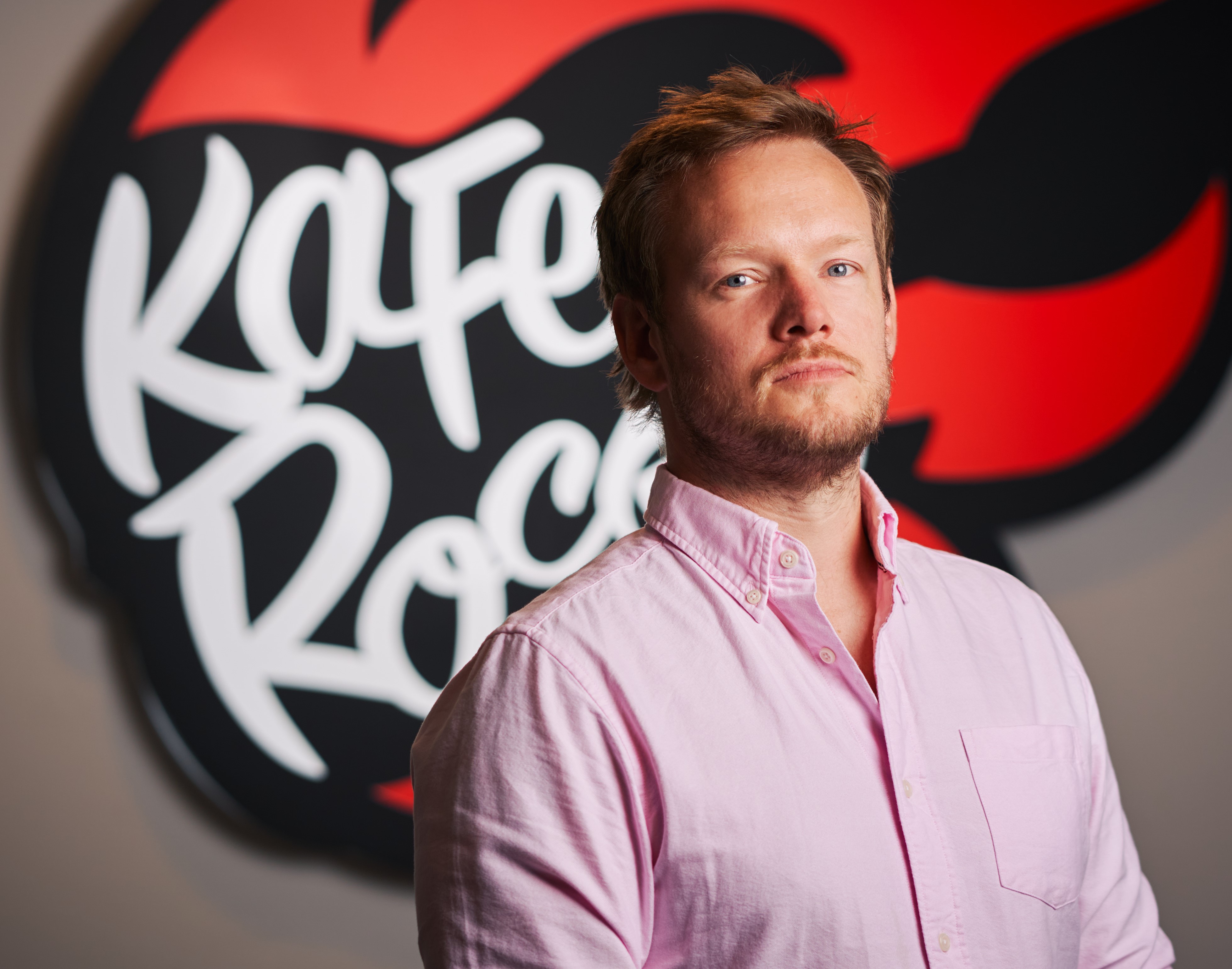Headshot of Simon Pilkington, CEO at KaFe Rocks Group, pictured in front of company logo on wall behind